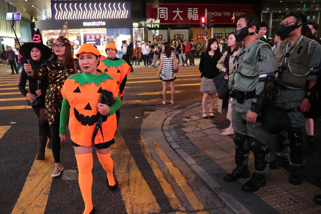Police officers geared up for action in Lan Kwai Fong on October 31, as revellers dressed up for Halloween arrive in the entertainment district on Hong Kong Island. Photo: Sam Tsang
