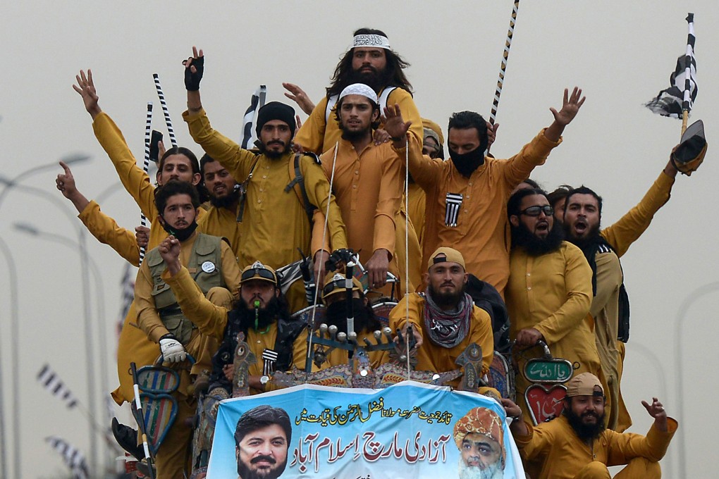 Supporters of the Islamist Jamiat Ulema-e-Islam party wave flags from atop a vehicle during the anti-government Azadi (Freedom) March. Photo: AFP