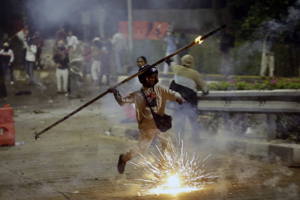 A student protester throws a burning stick at police during September’s riots in Jakarta, which have been widely blamed on the spread of hoaxes and misinformation. Photo: AP