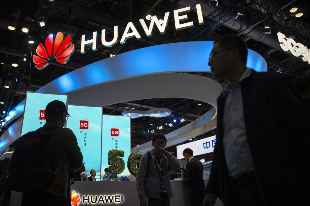 Attendees walk past the booth of Huawei Technologies at the PT Expo China trade show in Beijing on October 31. Photo: AP