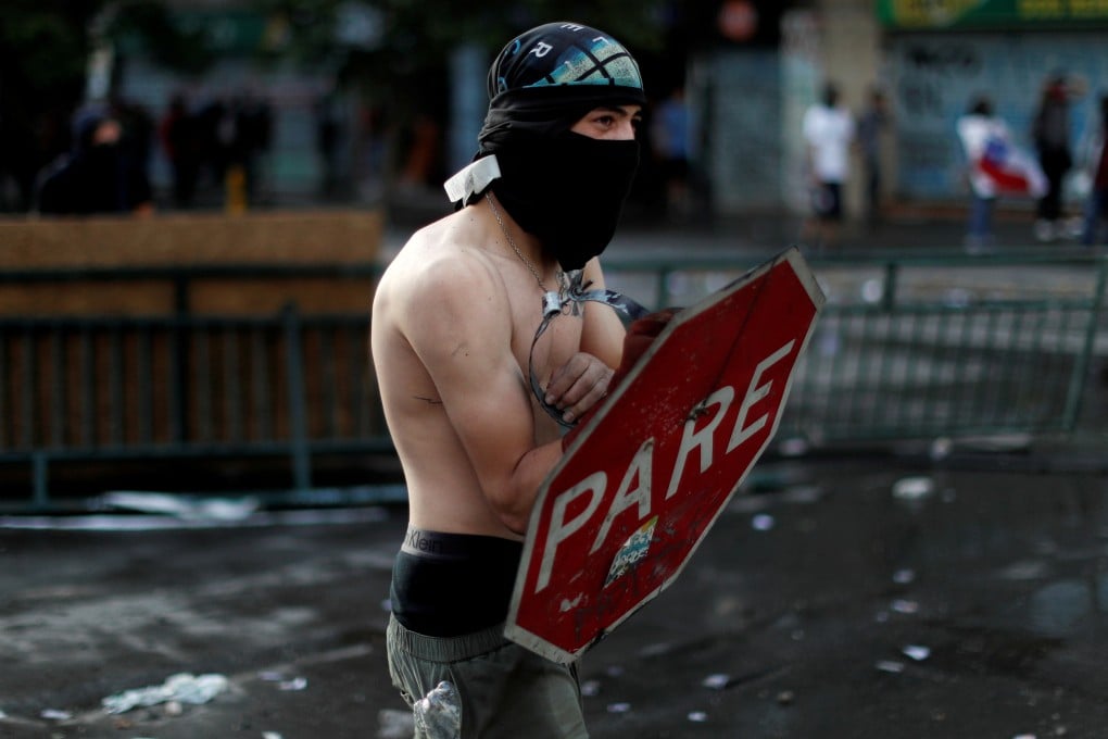 A demonstrator uses a stop sign as protection during a protest against Chile's government in Santiago, Chile, in October. Photo: Reuters
