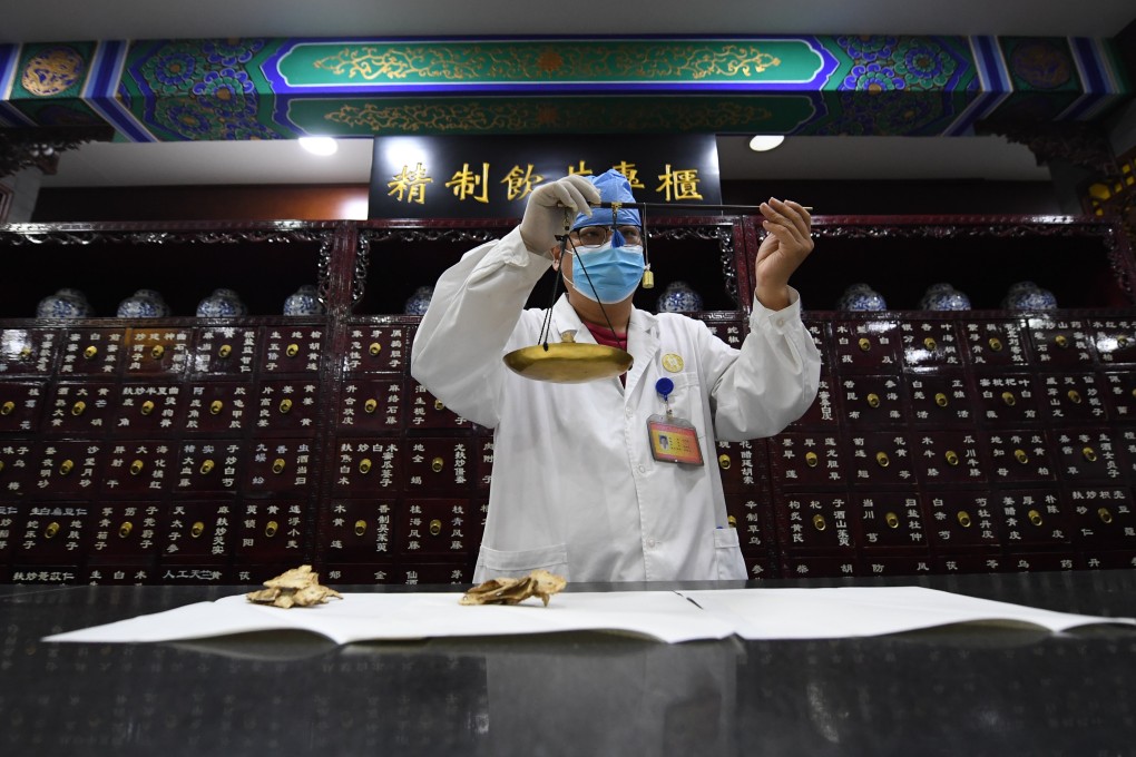 A pharmacist weighs herbs at a Tongrentang drugstore in Beijing. Photo: Xinhua