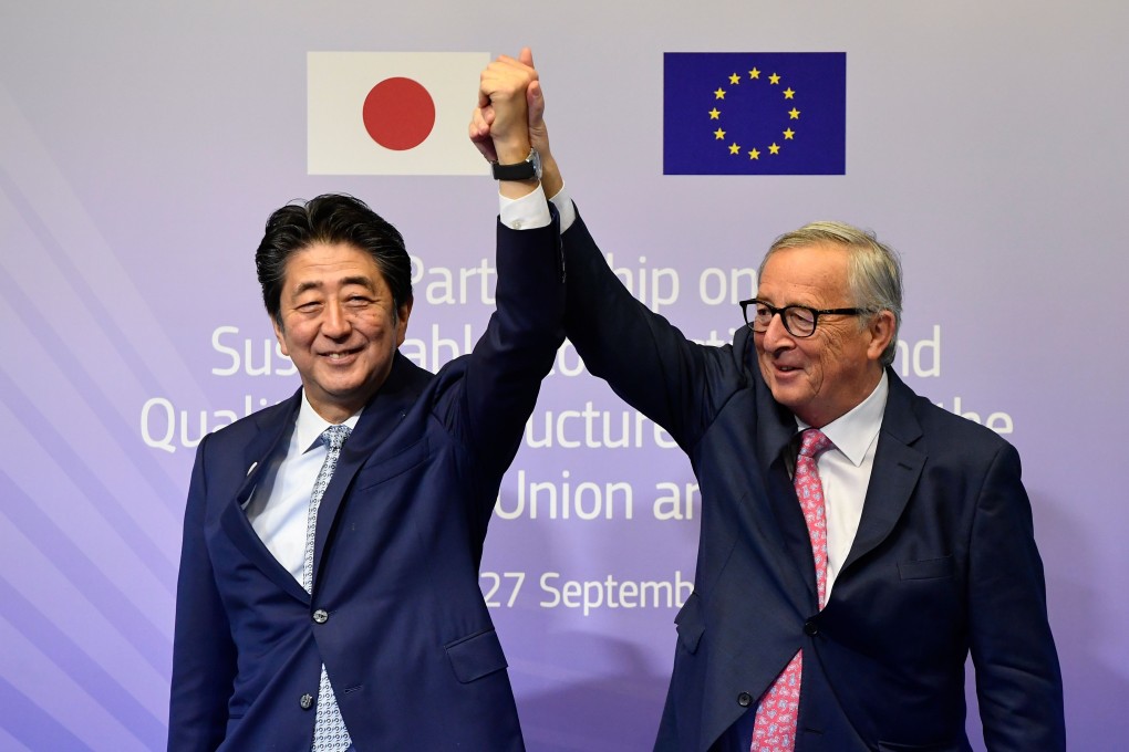 European Commission President Jean-Claude Juncker and Japan’s Prime Minister Shinzo Abe clasp hands during a conference in Brussels in September. Photo: AFP
