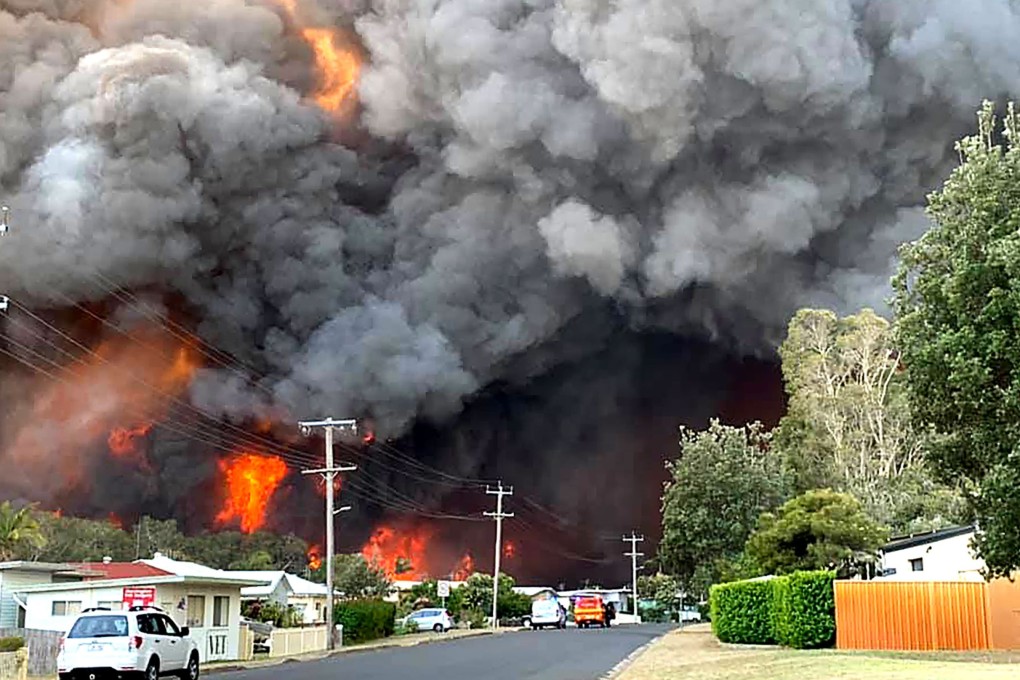 Flames from an out of control bush fire seen from a nearby residential area in Harrington, Australia, on Friday. Photo: Kelly-Ann Oosterbeek via Agence France-Presse