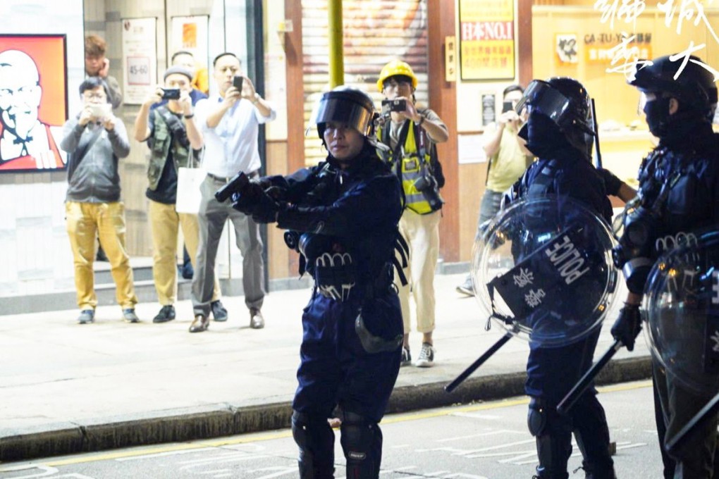 A police officer draws his gun in Yau Ma Tei. Photo: Editorial Board, CityU SU