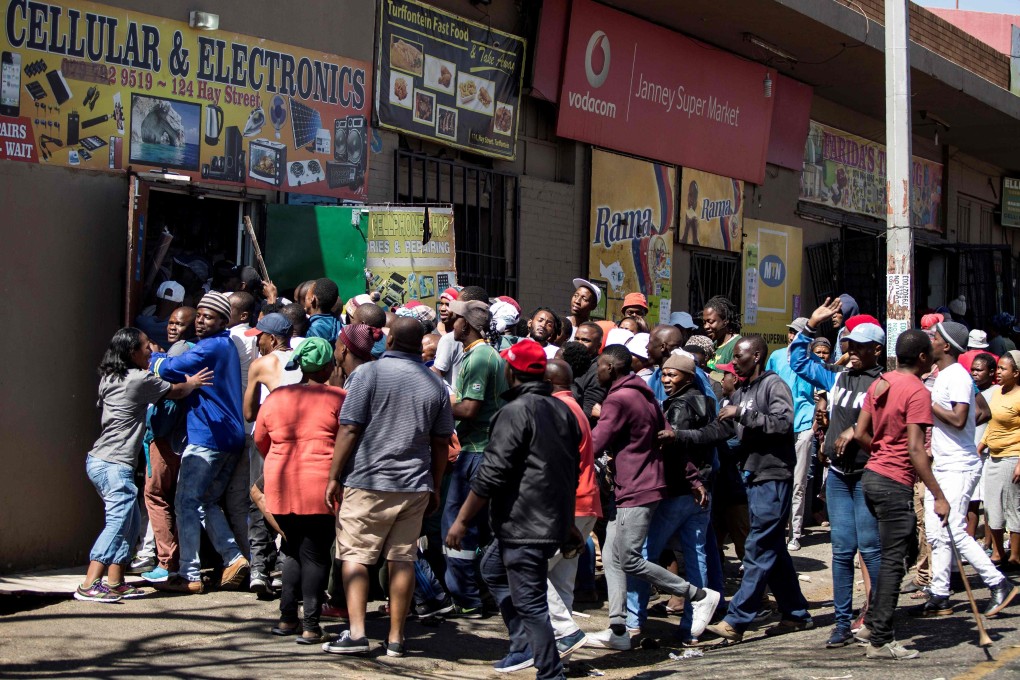 South African looters take items from foreign-owned shops during a riot in Johannesburg in September. Photo: AFP