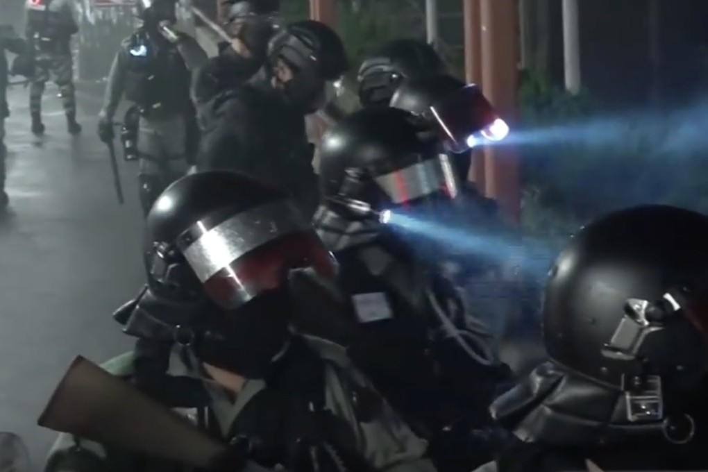 Riot police officers gathered on a bridge in Tuen Mun were filmed taunting protesters below, with one saying they would celebrate the death of a student. Photo: Cable TV
