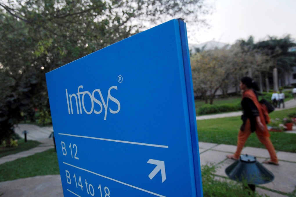 An employee walks past an Infosys sign in Bangalore. Photo: Reuters