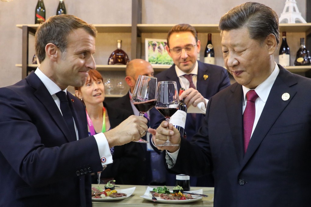 China’s President Xi Jinping (right) and French President Emmanuel Macron (left) taste wine as they visit France's pavilion during the China International Import Expo in Shanghai on Tuesday. Photo: AFP