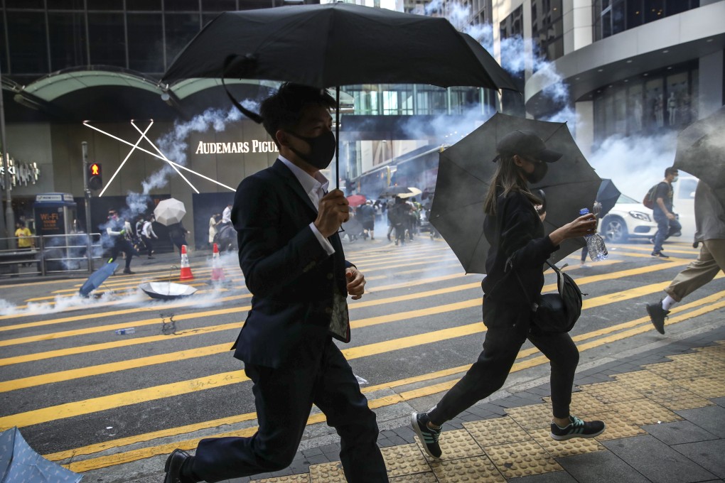 Anti-government protesters react to tear gar fired by riot police in Central following a march on the early hours of November 11, 2019. Photo: Winson Wong