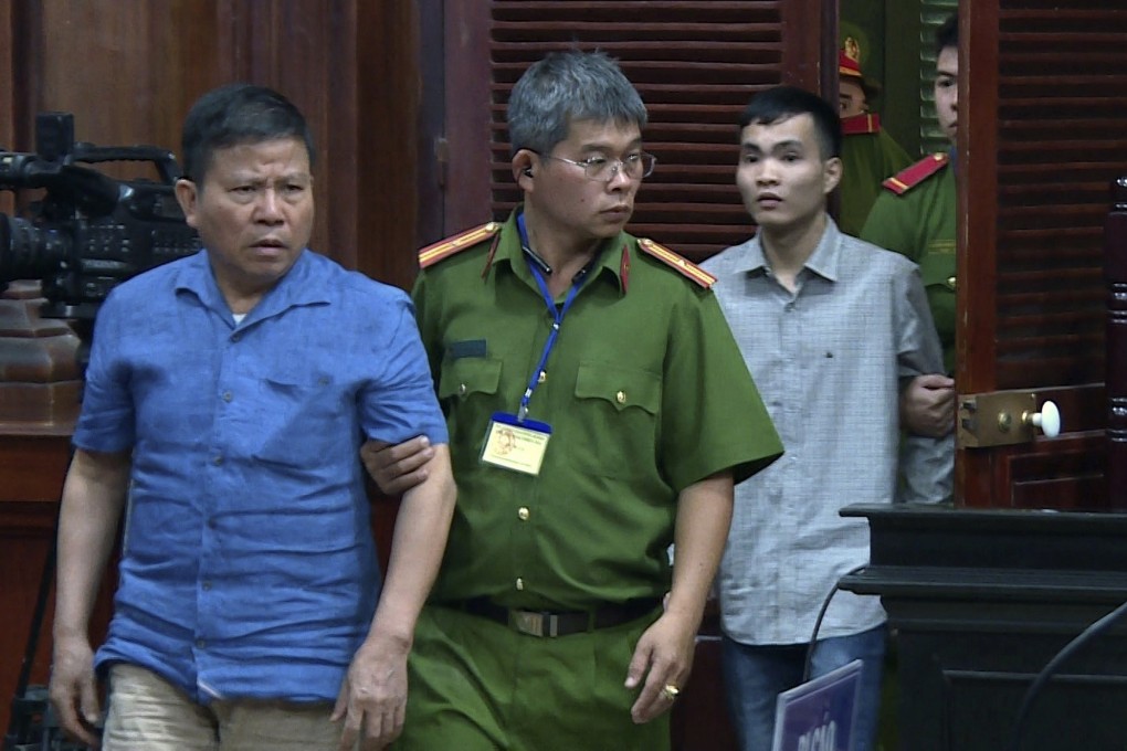 Vietnamese-Australian Chau Van Kham, left, is escorted into a courtroom in Ho Chi Minh City on Monday. Photo: AP