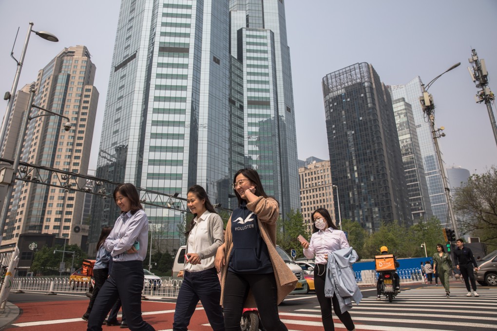 People cross a road in the Central Business District (CBD) area in Beijing, China in April 2019. Photo: EPA-EFE