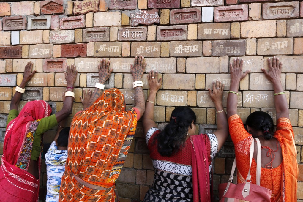 Hindu women pray to a pile of bricks which are expected to be used in the construction of a new temple in Ayodhya. Photo: AP