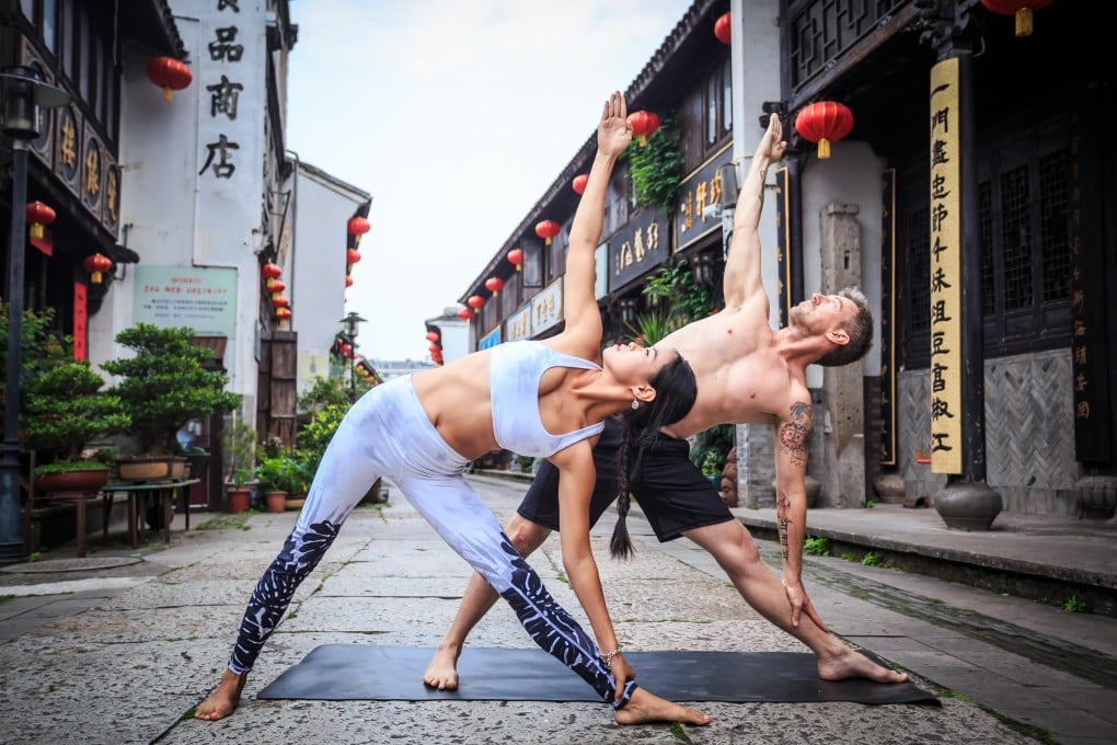 Yoga is taking off in China and local and international yogis are setting up schools there. Sara Pei and David Baimbridge demonstrate the triangle pose. Photo: Lin Zhi Yong