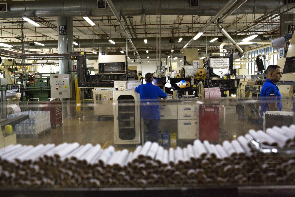 Cigarettes moves along a machine during the assembly process at the Philip Morris International’s Coltabaco facility in Medellin, Colombia. Photo: Bloomberg