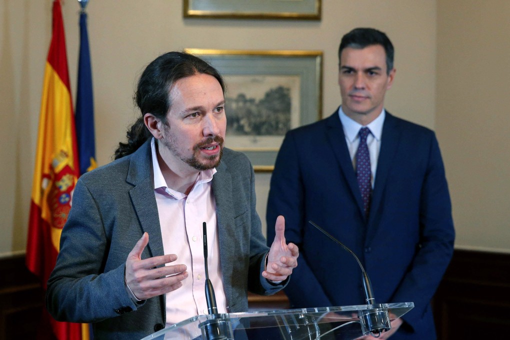 Spanish acting Prime Minister and Socialist Party leader Pedro Sanchez (right), listens to the leader of the Podemos party, Pablo Iglesias, after signing a pre-agreement to form a coalition government. Photo: EPA-EFE