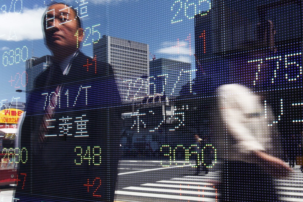 Pedestrians are reflected in an electronic stock board in Tokyo, Japan, in 2010. Research shows that just over half of active managers outperformed a broad range of US indices during the dotcom crash in the early 2000s. Photo: Bloomberg