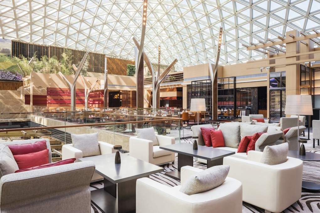 The soaring interior of Grill 58: the restaurant overlooks MGM Cotai’s atrium through a glass canopy.