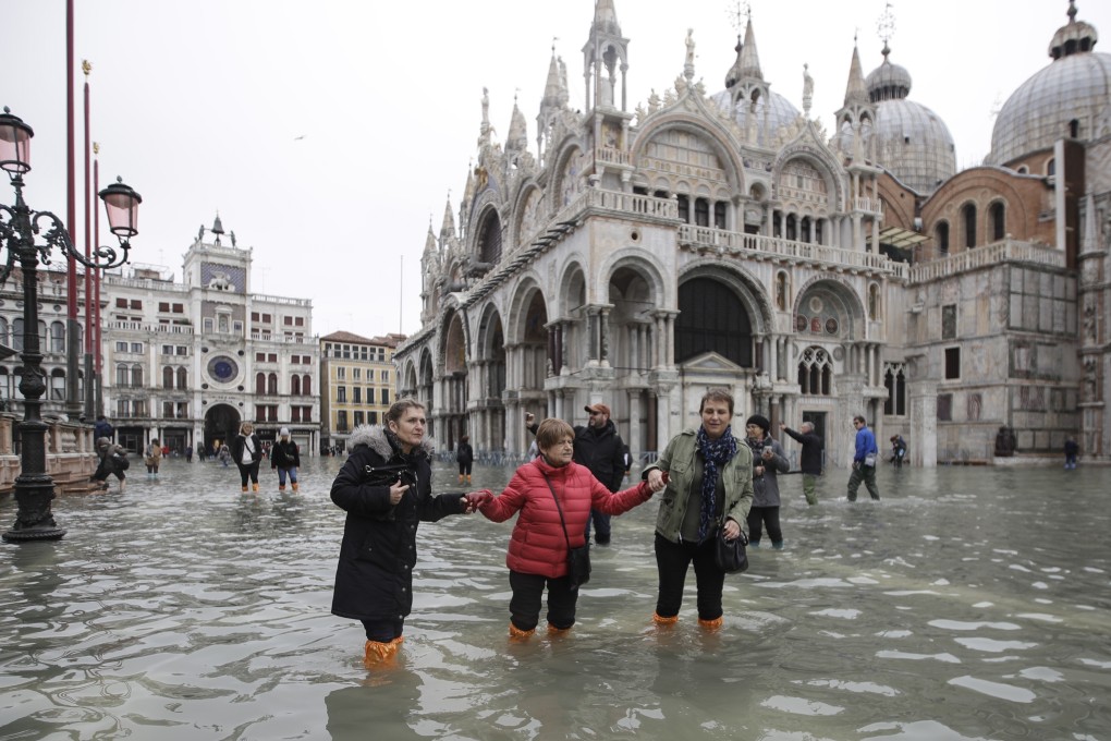 People wade through water in a flooded St. Mark’s Square in Venice, Italy on Wednesday. Photo: AP
