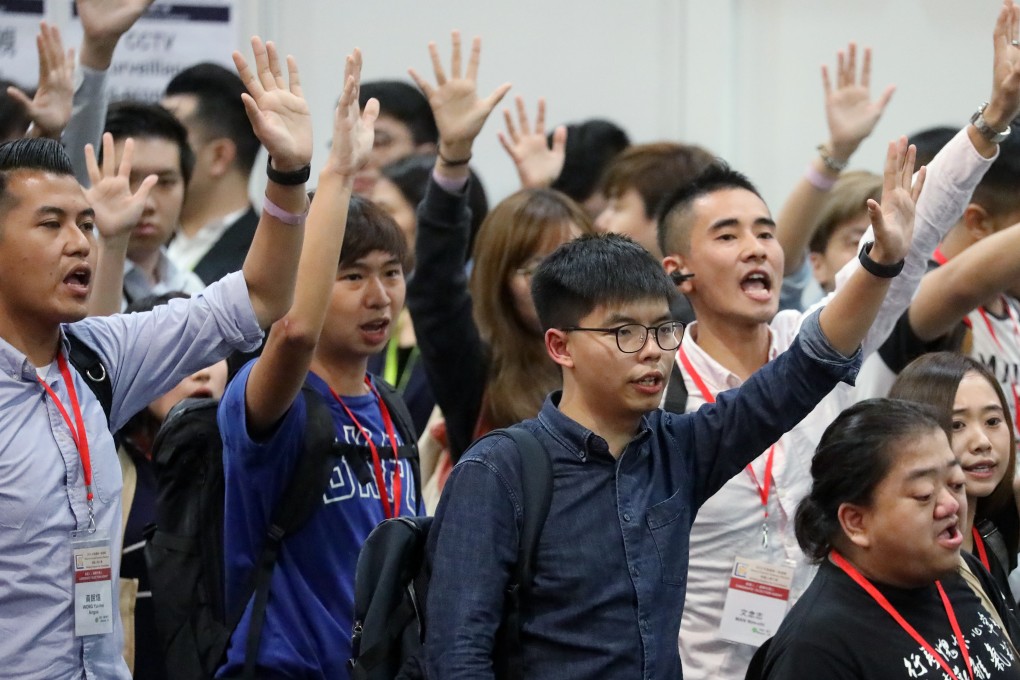 Activist Joshua Wong Chi-fung (centre) holds up five fingers to represent the five demands of anti-government protesters, at a briefing session for the district council elections, hosted by the Electoral Affairs Commission at AsiaWorld-Expo in Chek Lap Kok on October 24. Wong’s application to run was rejected a few days later. Photo: K.Y. Cheng