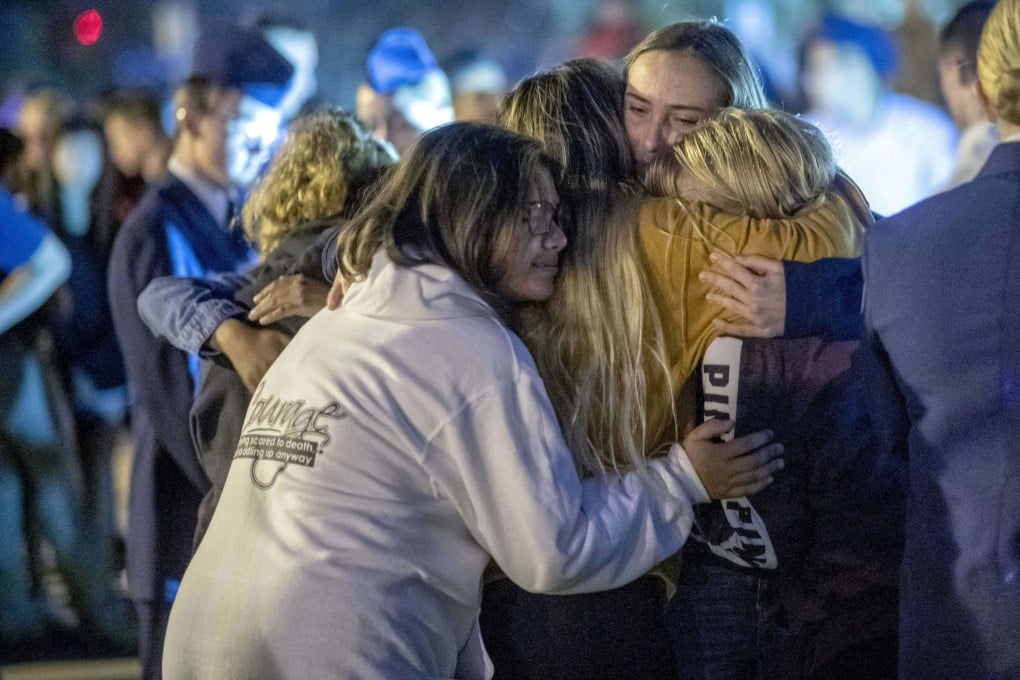 People hug each other during a vigil for the Saugus High School shooting victims at Central Park. Photo: AP