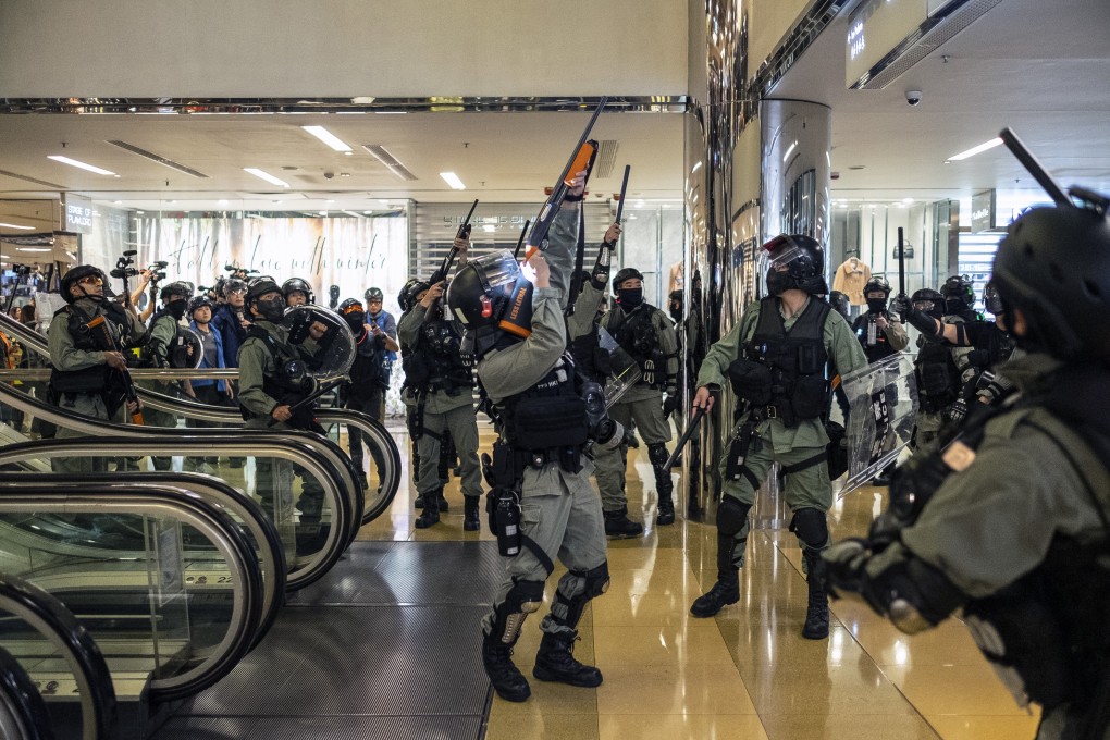 Hong Kong riot police point their non-lethal weapons towards protesters in a shopping mall in Taikoo Shing on November 3. Photo: Bloomberg