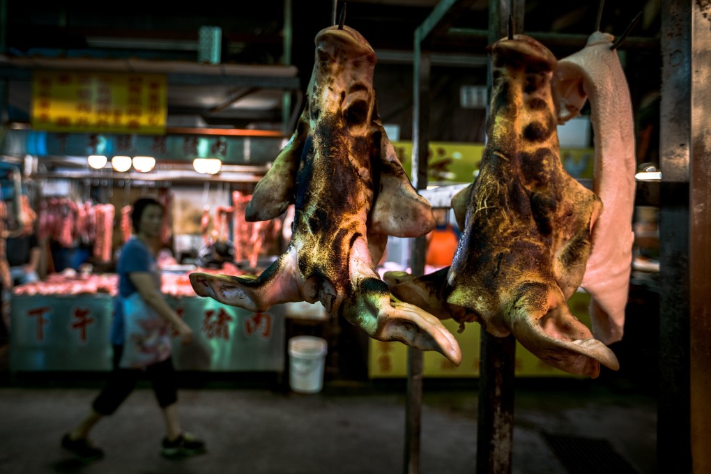 Pig faces hang in a wet market. Photo: Alamy
