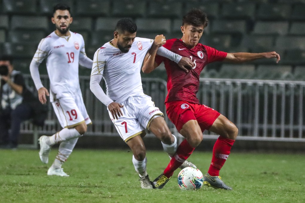 Youngster Tan Chun-lok tries to hold off a Bahraini rival during their World Cup qualifier at Hong Kong Stadium. Photos: May Tse