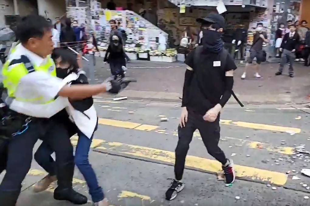 A video grab shows a police officer (left) shooting a protester in the chest in Hong Kong on Monday. Photo: AFP