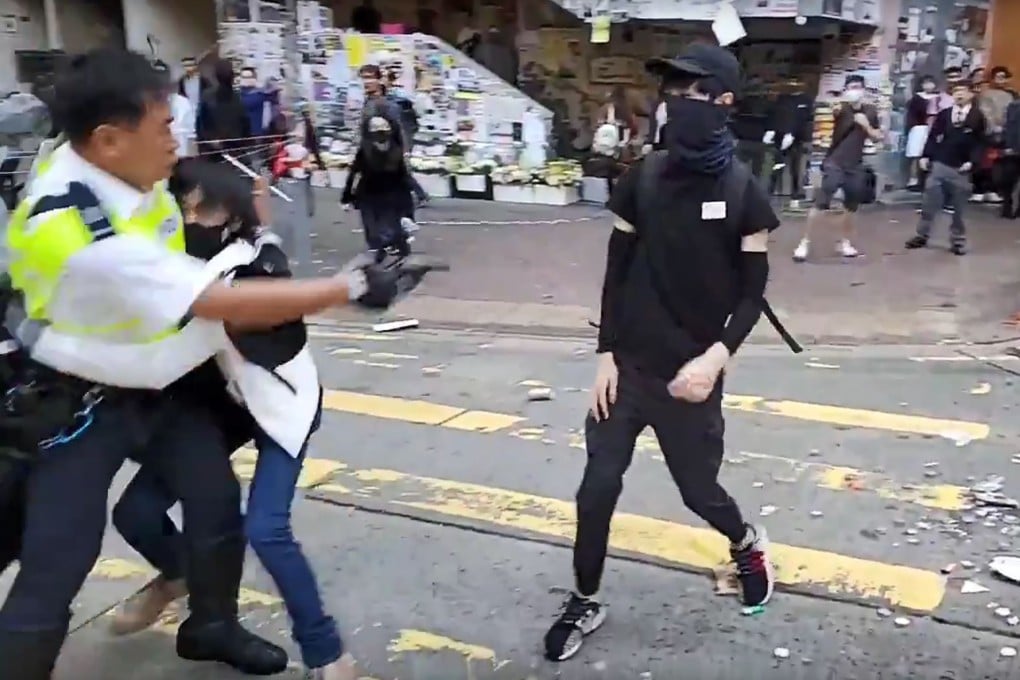 A video grab shows a police officer (left) shooting a protester in the chest in Hong Kong on Monday. Photo: AFP
