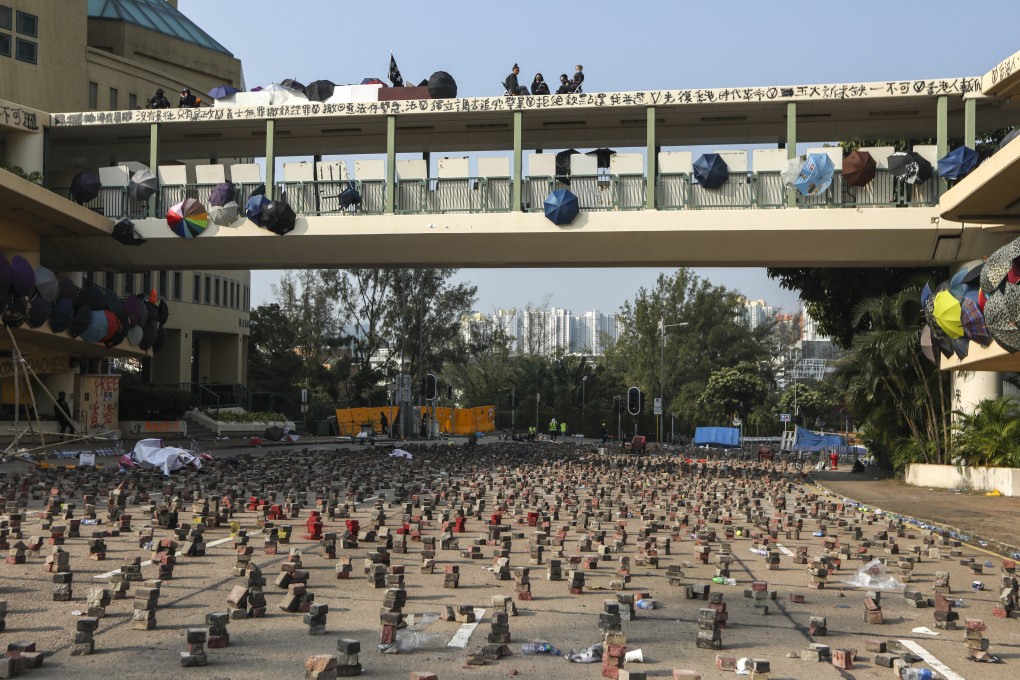 Anti-government protesters set up defences outside Baptist University in Kowloon Tong in preparation for clashes with police. Photo: Xiaomei Chen