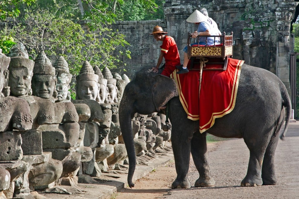 Tourists riding an elephant at Cambodia’s Angkor temple complex. Photo: Alamy