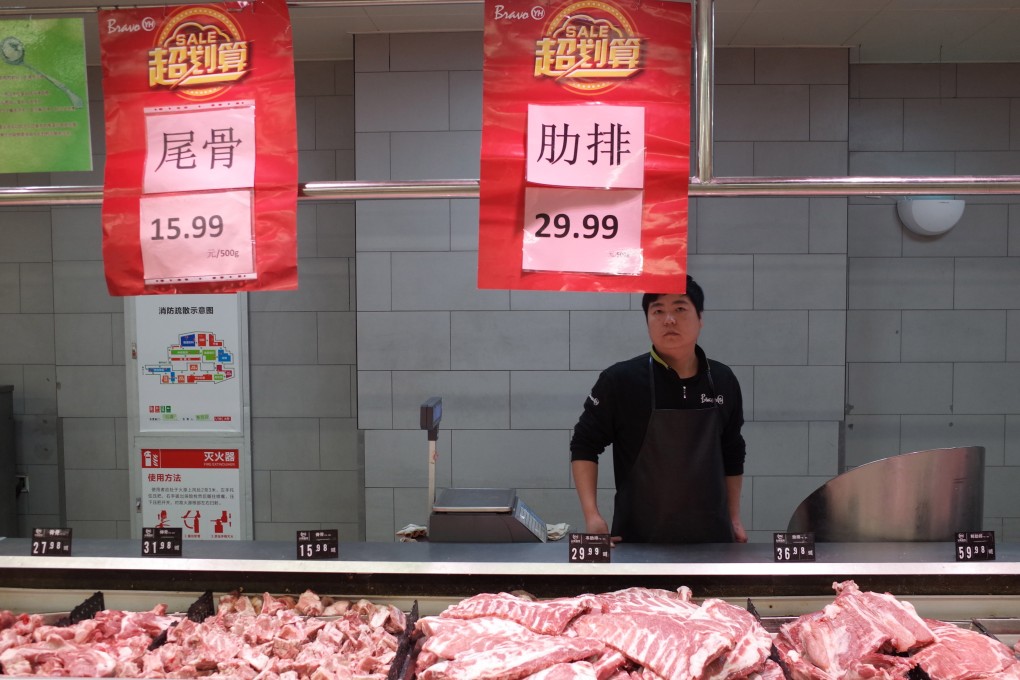 A salesman at a pork stall in a supermarket in Beijing. China’s consumer price index rose 3.8 per cent year on year in October, largely as a result of soaring pork prices. Photo: EPA-EFE