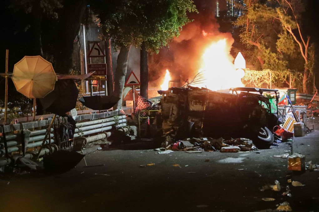 A car is set on fire at the end of No 2 Bridge at Chinese University before the protesters appear to retreat from the campus they have occupied for four days. Photo: Edmond So