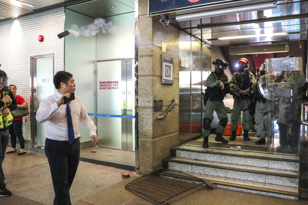 A passer-by walks on as tear gas is fired around him by riot police at Causeway Bay MTR station on September 8. Photo: Sam Tsang