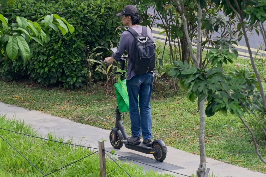 A food delivery man rides his electric scooter in Singapore. The city state has banned these devices from footpaths after a spate of accidents. Photo: AFP