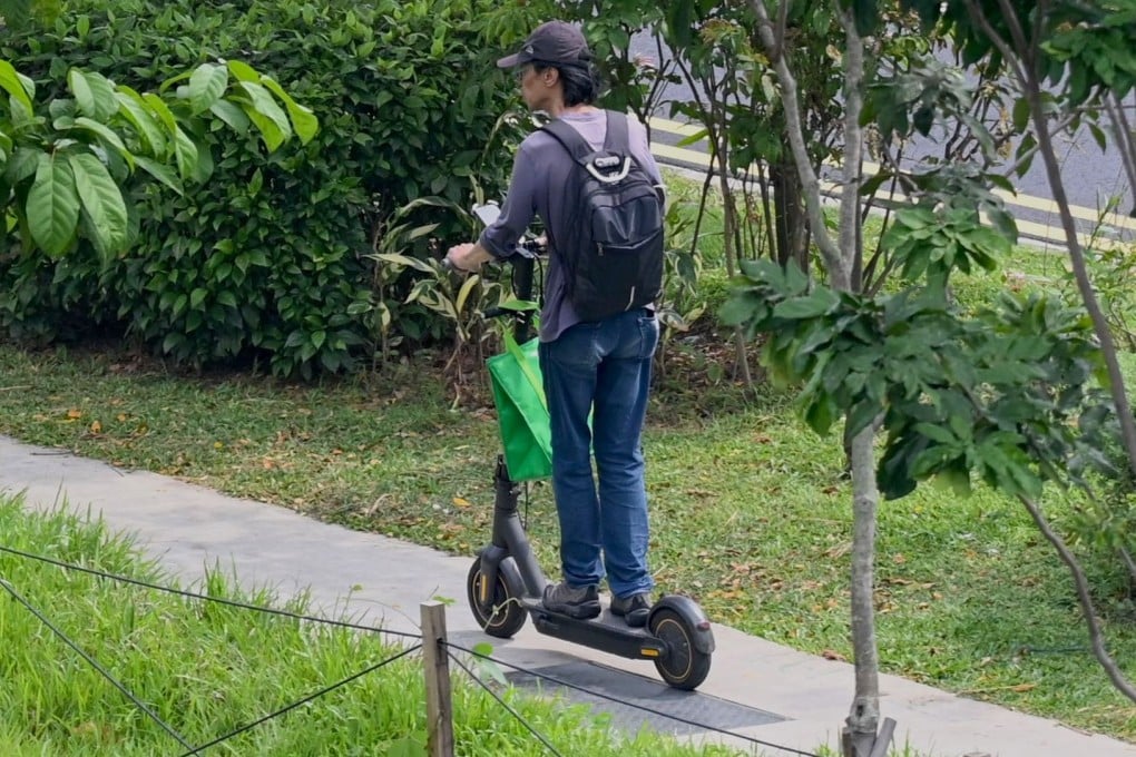 A food delivery man rides his electric scooter in Singapore. The city state has banned these devices from footpaths after a spate of accidents. Photo: AFP