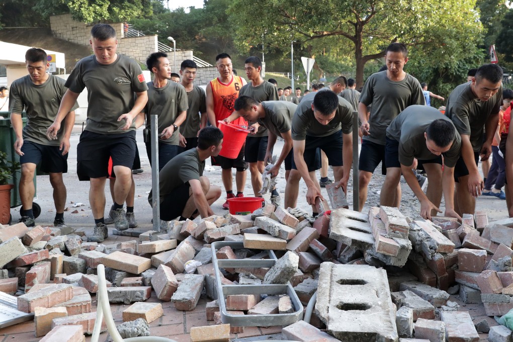 Soldiers from the PLA help clear roadblocks outside Baptist University. Photo: Edmond So