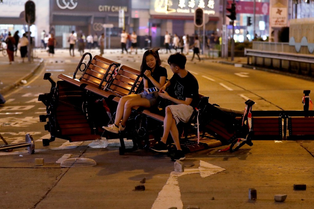People sit on a barricade made of benches left after an anti-government protest in Hong Kong, on October 20. Photo: Reuters