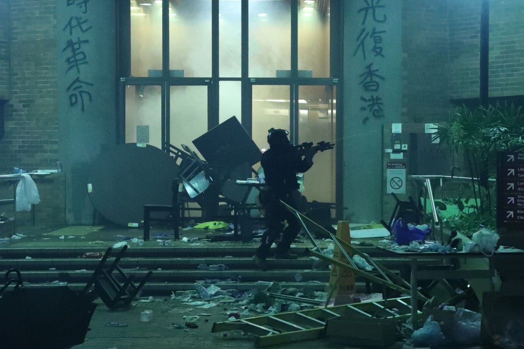 A police officer carrying a SIG516 assault rifle attempts to enter the Polytechnic University campus in Hung Hom on Monday morning. Photo: Sam Tsang