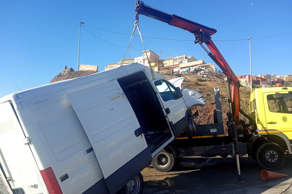 A crane removes the van that managed to enter Spanish Ceuta with 50 migrants inside. Photo: EPA