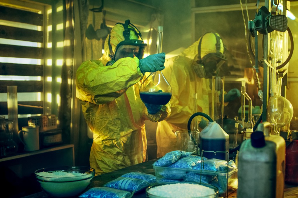 Two men in protective gear “cook meth” in a lab. Photo: Shutterstock