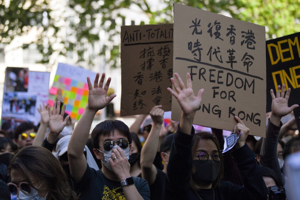 People hold up five fingers representing the five demands of protesters in Hong Kong during a demonstration in Sydney on September 29. Photo: EPA-EFE