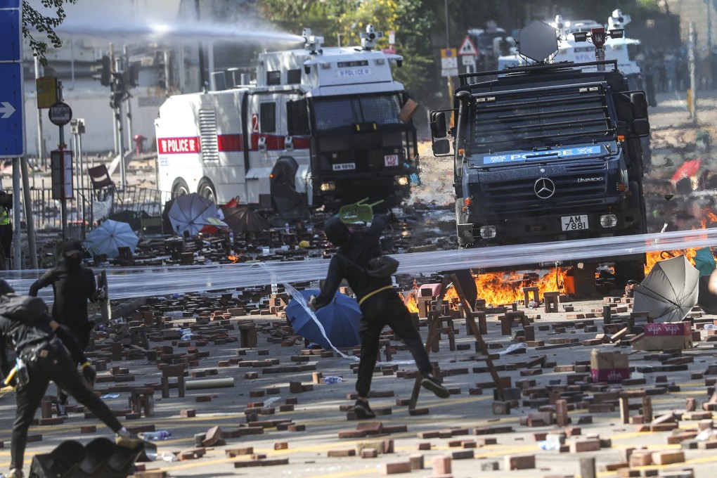 Water cannons move toward radicals at PolyU, who have occupied the campus since Sunday. Photo: Sam Tsang