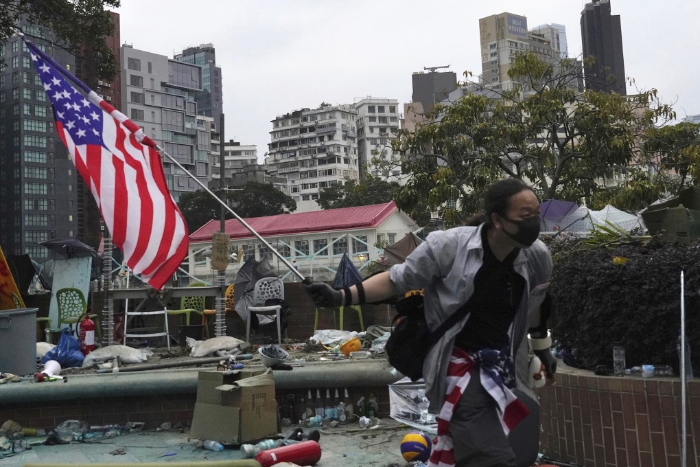 A protester holds an American flag on Wednesday at Polytechnic University, where anti-government protesters and police are locked in a stand-off. Photo: AP