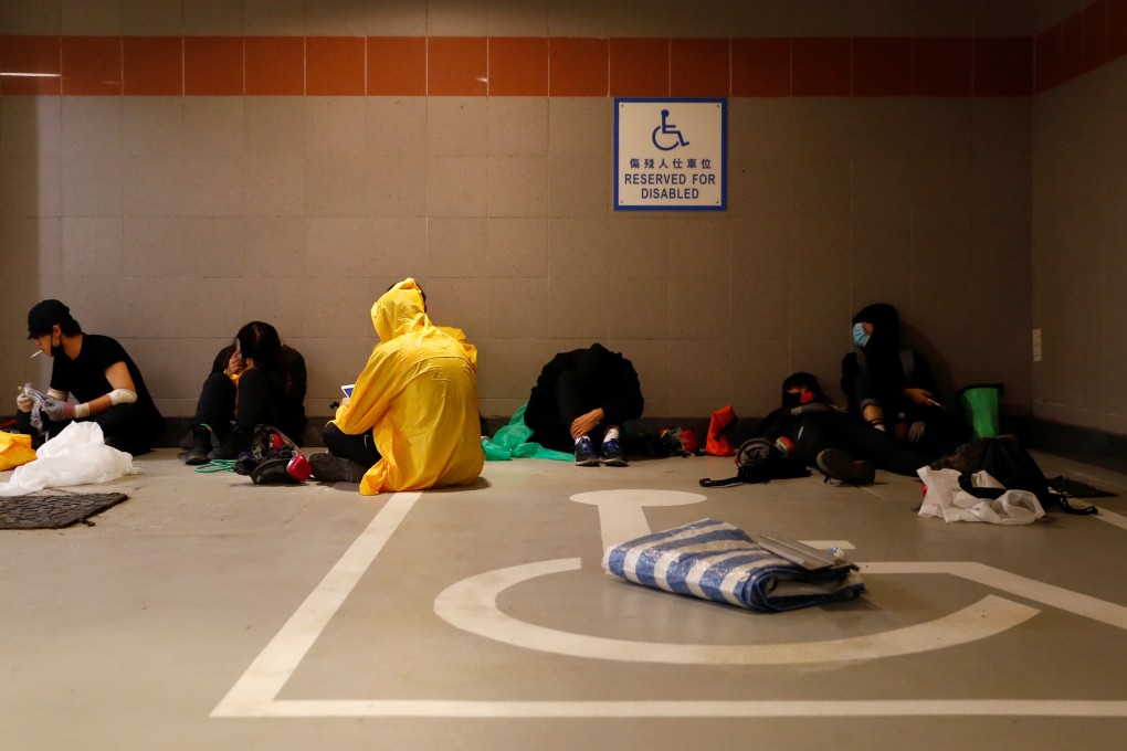 Those remaining on the PolyU campus have tried various methods to escape, such as this group waiting for an opportunity to make their way out through the sewerage system. Photo: Reuters/Thomas Peter