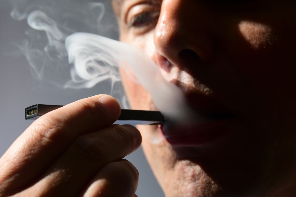 A man exhales smoke from an electronic cigarette. Photo: AFP