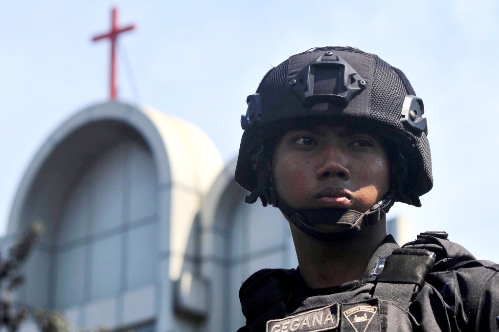 An Indonesian police officer stands guard in May last year near the scene of a bomb blast by a church in Surabaya, East Java, Indonesia. Photo: EPA