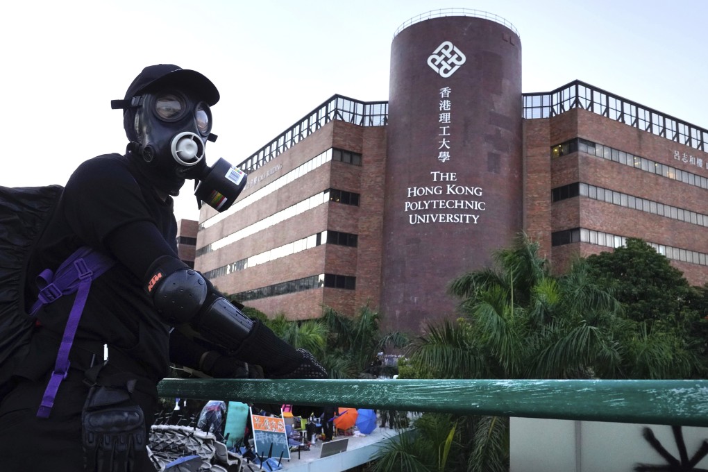 A protester stands on a bridge near Hong Kong Polytechnic University on Sunday. Five days later many still remain on the besieged site, despite another group of diehards leaving early on Thursday. Photo: AP