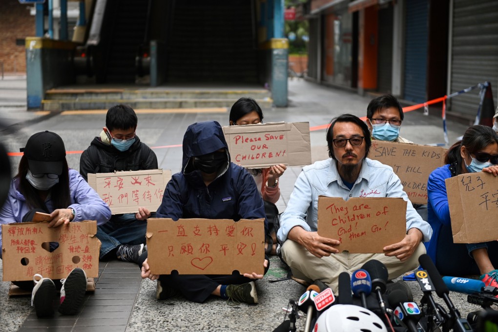 Family members of students barricaded inside Hong Kong Polytechnic University hold up signs during a protest on November 19. Photo: AFP
